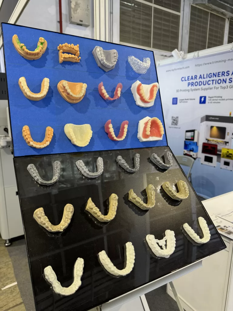 Display of 3D-printed dental resin models and aligner samples by Rayform Technology at Shanghai Dental Exhibition 2025.
