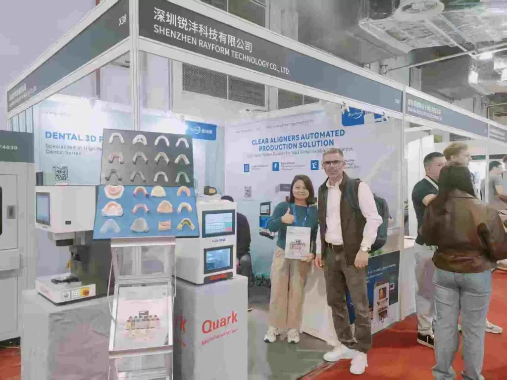 RayForm representative discussing dental printing with a visitor at an earlier Shanghai exhibition