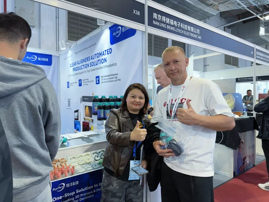 RayForm representative and a visitor reviewing dental samples at an earlier Shanghai exhibition